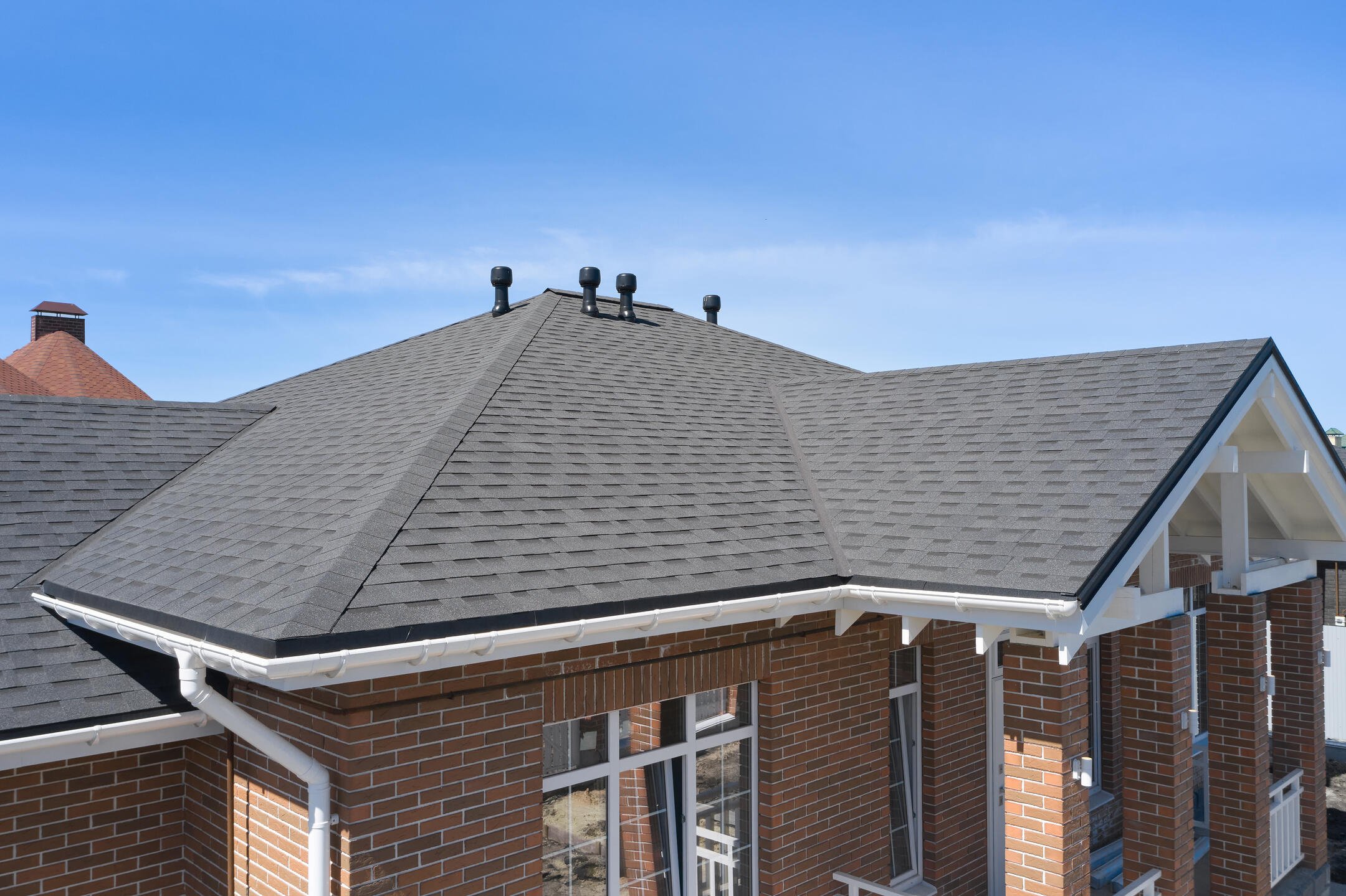 3 tab vs architectural shingles-gray architectural shingles on a brick house